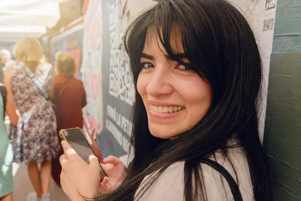 Buenos Aires 'teki genç Latin kadın, Venezuelalı turist, telefonunu kullanıyor ve kameraya büyük bir gülümsemeyle bakıyor..