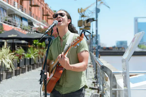 Genç Venezuelalı Latin gitaristin Buenos Aires 'te sokak sanatçısı olarak çalışan, sokakta müzik çalan ve şarkı söyleyen ön görüntüsü. Boşluğu kopyala