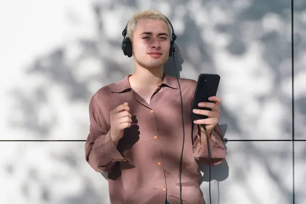 Jeune Homme Latin Aux Cheveux Blonds Tient Téléphone Portable Porte Image En Vente