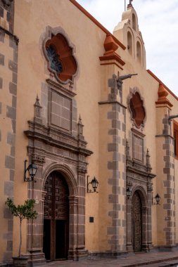 The building is a church with a large window on the front. The building is old. Historic center of Queretaro City, decorations and traditions to celebrate Mexico's Independence Day, colonial architecture, alleys and facades