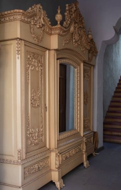 A large, ornate cabinet with a mirror on the front. The cabinet is made of wood. Historic center of Queretaro City, decorations and traditions to celebrate Mexico's Independence Day, colonial architecture, alleys and facades