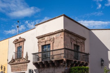 Balkonu ve penceresi olan bir bina. Balkon siyah ve pencere beyaz. Queretaro şehrinin tarihi merkezi, Meksika 'nın Bağımsızlık Günü' nü, sömürge mimarisini, sokaklarını ve cephelerini kutlamak için dekorasyon ve gelenekler
