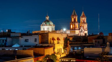 Geceleri yüksek binaları ve kilisesi olan bir şehir. Binalar aydınlandı. Queretaro 'nun tarihi merkezi, sömürge mimarisi, Meksika' nın Bağımsızlık Günü kutlamaları için dekorasyonlar.
