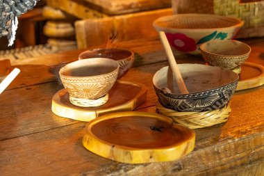 A wooden table with a variety of bowls and a spoon. The bowls are of different sizes and shapes. Historic center of Queretaro, colonial architecture, decorations for the celebration of Mexico's Independence Day.