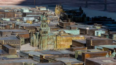 A model of a city with a tall building in the center. The buildings are made of metal. Historic center of Queretaro, colonial architecture, decorations for the celebration of Mexico's Independence Day.