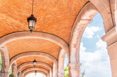 Bir binanın kemerli tavanı bir dizi lambayla aydınlatılır. Lambalar eşit aralıklı. Queretaro 'nun tarihi merkezi, sömürge mimarisi, Meksika' nın Bağımsızlık Günü kutlamaları için dekorasyonlar.