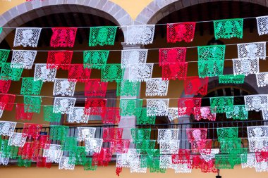 Arkasında beyaz bir bina olan küçük bir kasaba meydanı. Binanın üzerinde bir bayrak var. Queretaro 'nun tarihi merkezi, sömürge mimarisi, Meksika' nın Bağımsızlık Günü kutlamaları için dekorasyonlar.