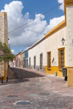 Arkasında beyaz bir bina olan küçük bir kasaba meydanı. Binanın üzerinde bir bayrak var. Queretaro 'nun tarihi merkezi, sömürge mimarisi, Meksika' nın Bağımsızlık Günü kutlamaları için dekorasyonlar.
