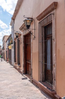 Arkasında beyaz bir bina olan küçük bir kasaba meydanı. Binanın üzerinde bir bayrak var. Queretaro 'nun tarihi merkezi, sömürge mimarisi, Meksika' nın Bağımsızlık Günü kutlamaları için dekorasyonlar.
