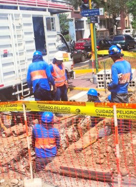 Üniformalı elektrikçiler sokaktaki elektrik kablolarını tamir ediyor kaldırımlardaki elektrik kablolarını tamir ediyor.