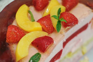 Çilekli ve şeftalili kek taze nane ile süslenmiş.