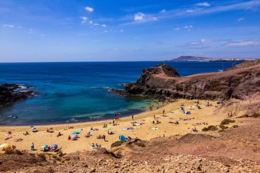 Lanzarote 'de kristal berrak deniz manzarası. Mavi gökyüzü ve arka planda dağlar.