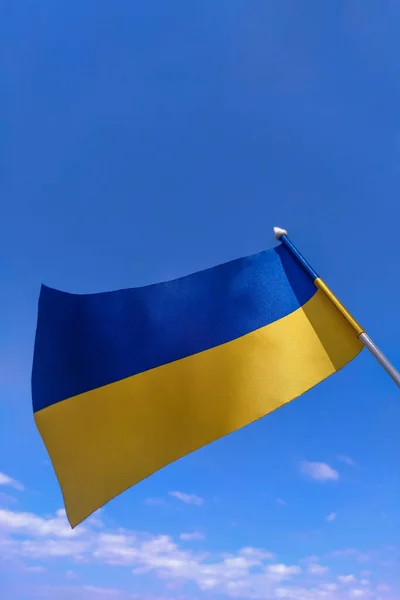 Ukraine flag waving in the wing against blue sky and white clouds. State symbol of Ukraine. Vertical wallpaper of Independence Day of Ukraine and National Flag Day of Ukraine