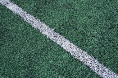 Futbol için yeşil spor sahasının dokulu yapay çimlerinde beyaz köşegen çizgisi. Bir spor çim sahasının sınırı