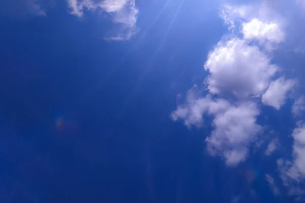 Beyaz bulutlar ve güneş ışınlarıyla mavi gökyüzü gradyanı 