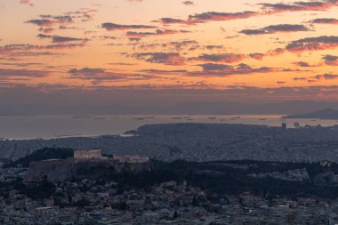Atina 'nın gün batımı manzarası, Lycabettus Dağı' ndan liman ve rıhtıma doğru çekildi. Parthenon orta sahada görülebilir..