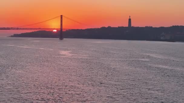 ポルトガルのリスボンにある25のデカルト橋の静的な空中撮影 橋の後ろに太陽が昇り 交通が橋を渡って移動しています — ストック動画