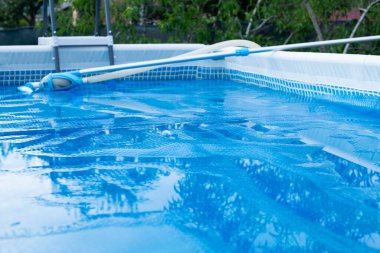 Elektrikli süpürgeyle yüzme havuzu. Solar film havuzu kapsıyor. Suyu ısıtma ve kirliliği koruma filmleri. Havuz servisi