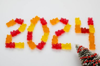 Renkli tasarımla 2024 yılınız kutlu olsun. 2024 yılı yuvarlak renkli ayıcıklar ve noel ağacından hazırlanırken