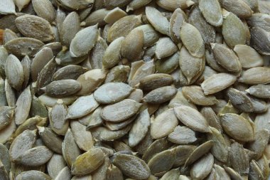 Pumpkin seeds without shells fixed with a close-up photo shooting. View from above. clipart