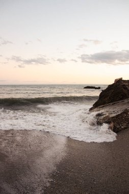 Sahil şeridi Dinginliği: Nazik Dalgalar Kum Sahilini Ritmik Kıyı Dansıyla Kucaklıyor
