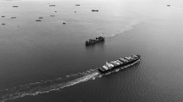 black and white cargo container ship full speed sailing in sea import and export business and industry logistic goods transportation of international by container ship in ocean fright aerial view