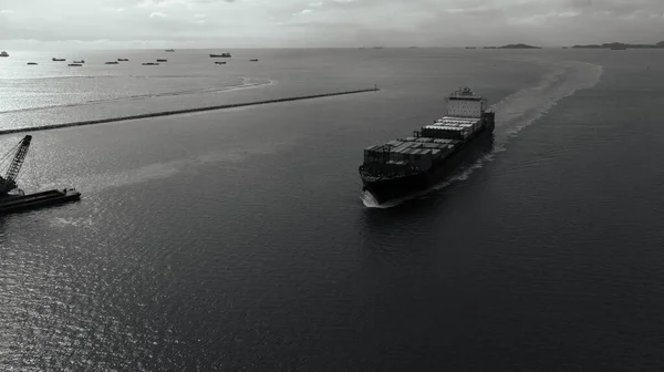 black and white cargo container ship full speed sailing in sea import and export business and industry logistic goods transportation of international by container ship in ocean fright aerial view