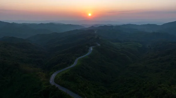 landscape shadow of valley and thin mist caused by light of sunset in evening and Road No.1081 also hnow as Sky Road, winding along ridge between Pua Distric, Nan Province, is beautiful route north of thailand,aerial view from dron