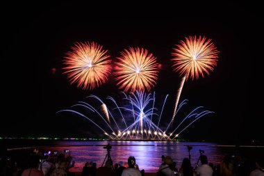 PATTAYA, CHONBURI, THAILAND, NOVEMBER Pattaya Uluslararası Havai fişek Festivali 'nde güzel renkli bir gece sahnesi ve siluet turist grubu akıllı telefonlar ve DSLR kameralı havai fişek gösterisi çekiyor ve kaydediyor. 