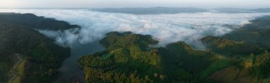 Sabaha karşı sisli panoramik peyzaj Tayland 'ın kuzeyindeki ulusal parktaki baraj veya rezervuarın üzerine ağır basar.,