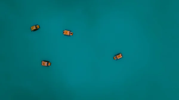 緑の水の色の背景に浮かぶ小さなボートやいかだの観光客 ポストカードや背景抽象的な概念のための最小限の写真 ドローンからの空中トップビュー — ストック写真