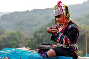 CHIANG RAI, THAILAND - February 20,2020 young girl karen holding and drying coffee beans on the floor at her home north of Chiang Rai, Thailand. business and industry family and community concept.