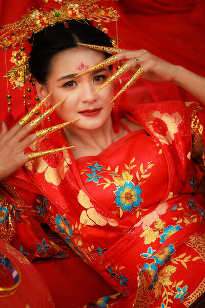 portrait beautiful asian woman in red chinese traditional costume in chinese temple, chinese new year concept
