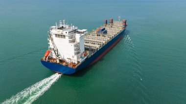 ship transport sailing full speed in green sea photograph from drone camera aerial view,