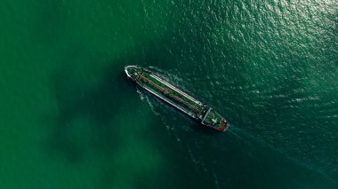 Oil Ship tanker or Liquid fied Petroleum Gas (LPG) sailing in green sea aerial top view from drone,