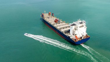 cargo container ship carrying in sea to import export goods and distributing products to dealer and consumers international aerial photography from drone,