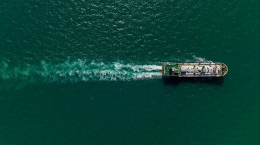 Oil Ship tanker or Liquid fied Petroleum Gas (LPG) sailing in green sea aerial top view from drone,