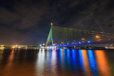 Rama VIII Köprüsü ya da şehri Chao Phraya Nehri 'ne bağlayan praram 8 köprüsü. Tayland 'da alacakaranlıkta ve lazer ışık gösterisinde, Kasım 2022