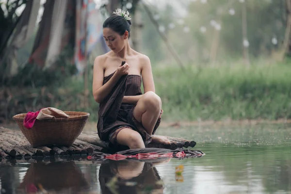 亚洲女人坐在木桥上 在河里洗衣服 洗衣服和性感的亚洲风格概念 — 图库照片