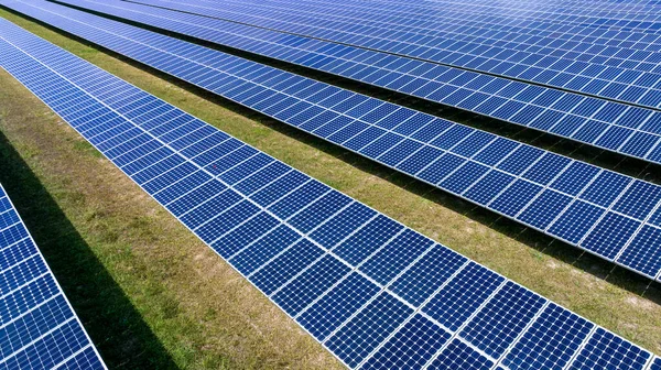 Blue Solar panel farm or solar power plantation.  Alternative renewable energy with photovoltaic cell industry. Green energy technology for future world concept, drone point of vie