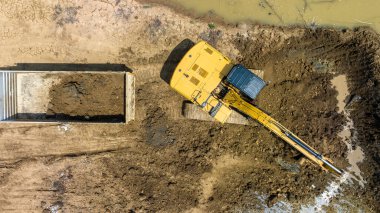 Su depolamak için bir gölet inşa etmek için çöplük kamyonuna toprak kazmak tarım için kurak mevsimde tarım için, insansız hava aracından hava manzarası için.