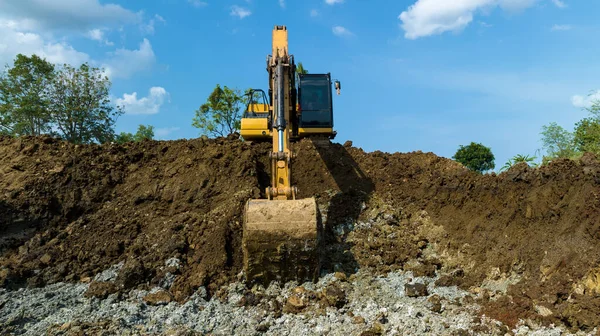 stock image excavating soil into a dump truck to build a pond for store water for use in the dry season for agriculture, angle view blue sky background,