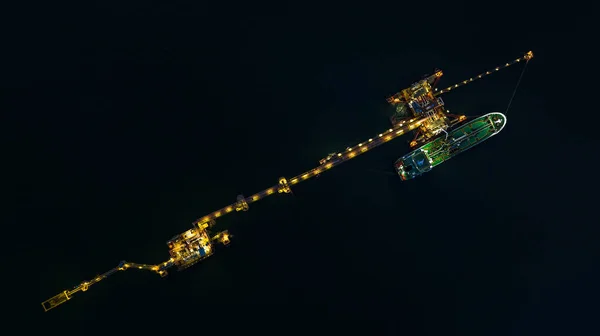 油轮船舶在港口装货的空中俯瞰图 油轮船舶在典型的岸上作业 夜间机械装卸臂和输油管道清晰可辨 — 图库照片