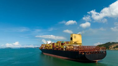 cargo logistic container ship sailing in green sea to import export goods and distributing products to dealer and consumers across worldwide, by container ship aerial view from drone,