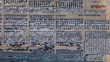 Otomobil fabrikasının otoparkına park edilmiş yeni arabaların hava manzarası, RORO 'nun uluslararası taşımacılığını bekliyor.,
