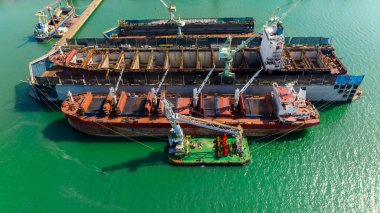 Konteynır gemisi yeşil denizde tersanede onarım ve onarım yapıyor.