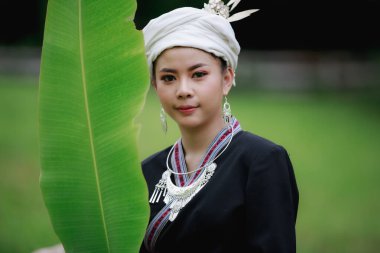 Doğal ışık portresi. Güzel Asyalı kadın. Geleneksel Tayland kültürü giysisi giyip muz yaprağı tutuyor.,