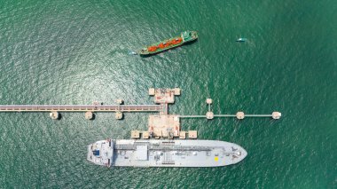 Denizdeki ham petrol istasyonu, köprü boru hattı petrol gemisinden ham petrol boşaltımı, konteyner gemisiyle sanayi taşımacılığı, açık deniz manzarası.