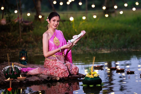 罗克拉通节 泰国妇女在河边的木筏上握着花环 身着传统泰国服装的亚洲妇女在罗克拉通节 泰国的传统和文化中带着花环飘扬 — 图库照片