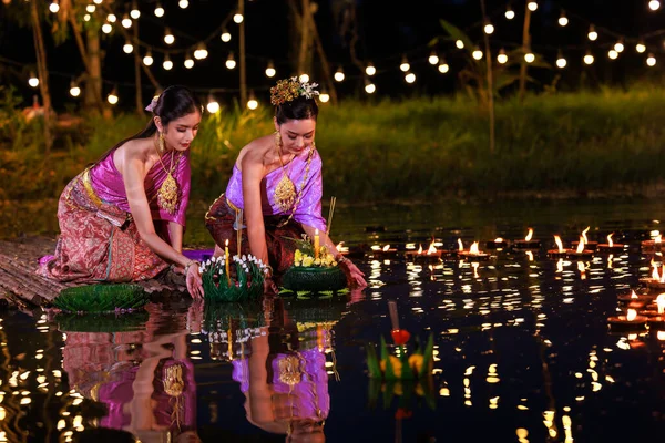 เทศกาลลอยกระทง งไทยสองคนถ งทองน งอย บนแพร มแม งเอเช ยในช ดประเพณ ไทยน — ภาพถ่ายสต็อก